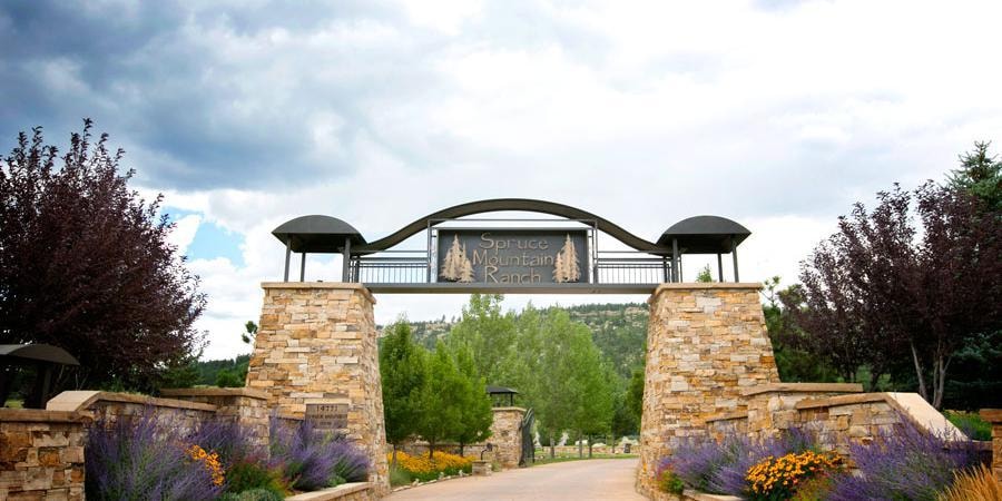 Spruce Mountain Ranch entrance gate with stone pillars and landscaping